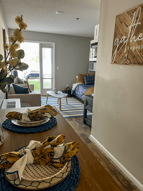 a living room and dining room with a table with plates on it