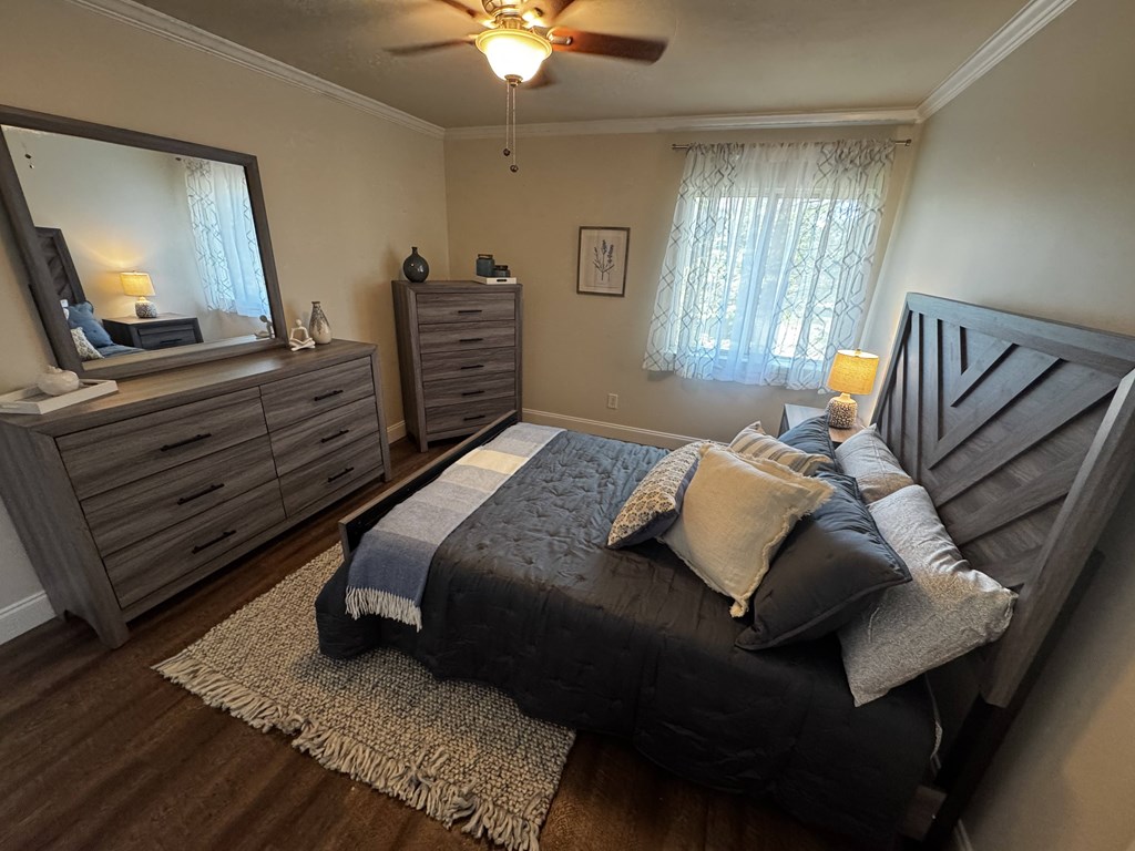 A bedroom with a bed, dresser, and mirror.