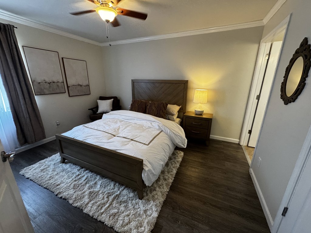 A bedroom with a large bed and a ceiling fan.