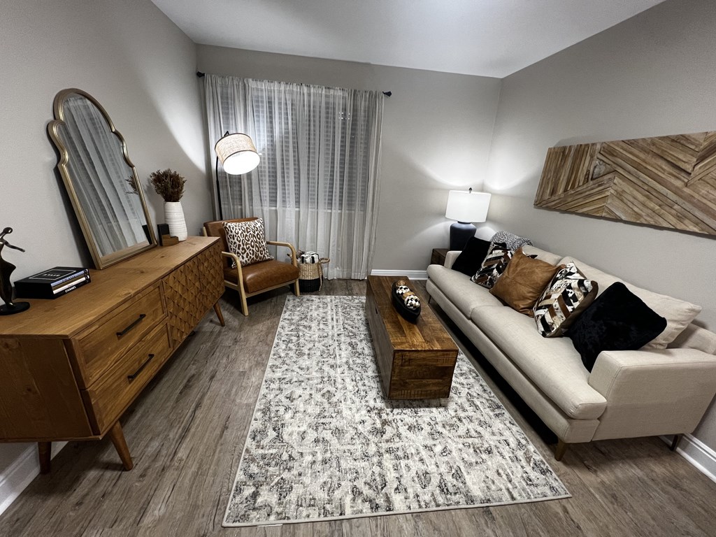 a living room with a couch and a dresser and a mirror