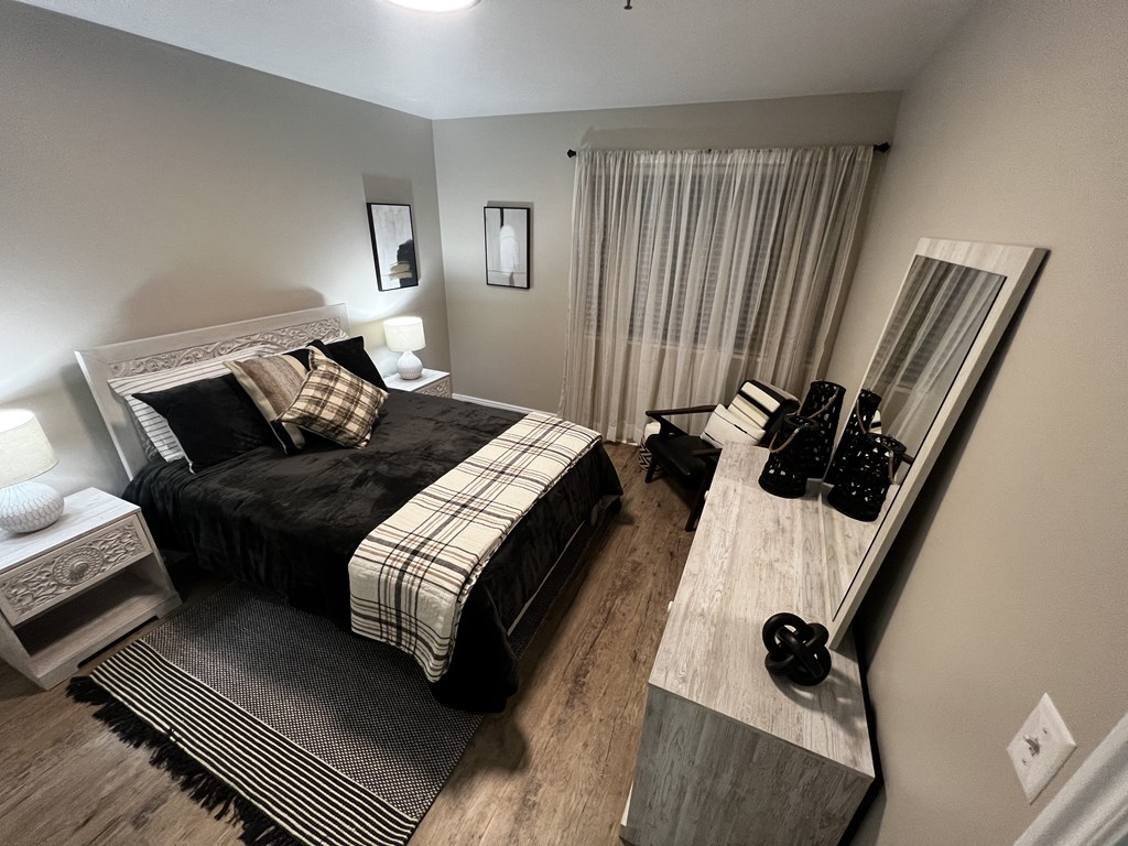 a bedroom with a bed and a desk with a mirror