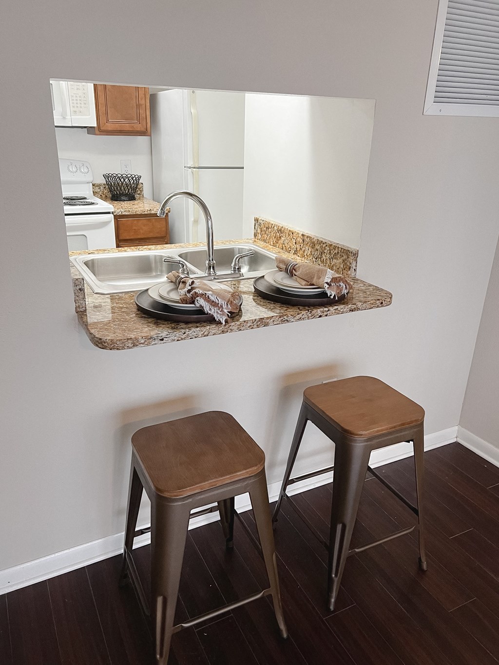 a kitchen with a sink and two stools in front of a counter with a