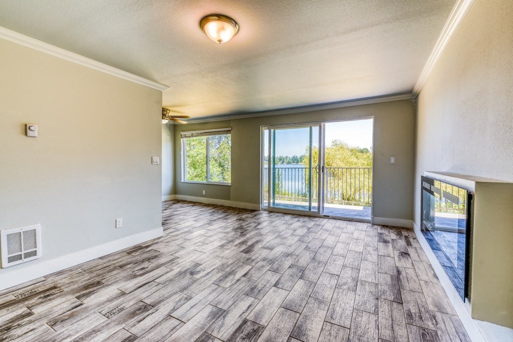 an empty living room with sliding glass doors to a balcony