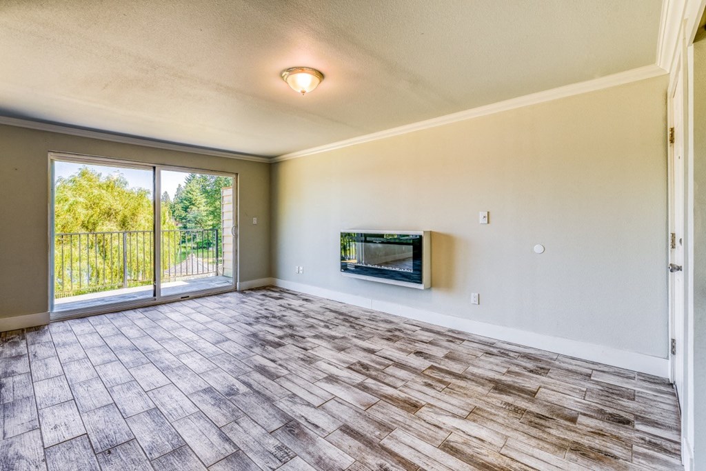 an empty living room with a fireplace and a sliding glass door