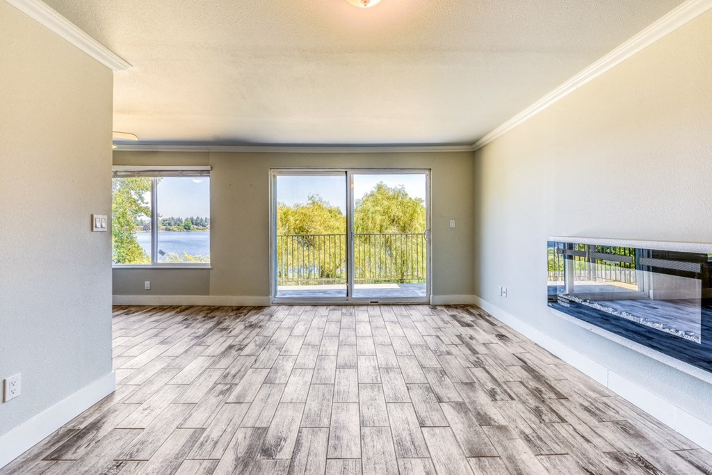 an empty living room with sliding glass doors and a view of the lake