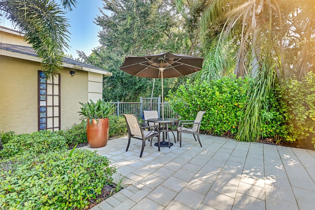 A patio with a table and chairs under an umbrella.