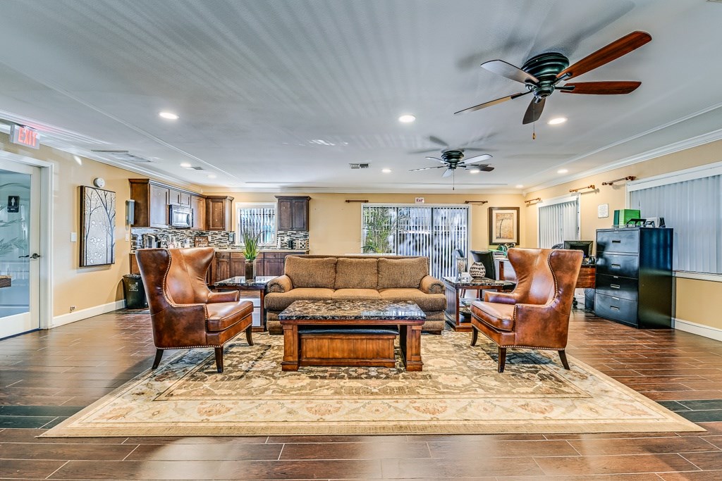 A living room with a brown sofa, two chairs, and a coffee table.