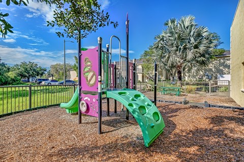 A playground with a pink and green slide. at Westminster Chase Apartments, Florida