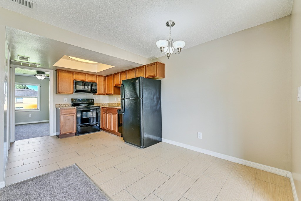 A kitchen with black appliances and wooden cabinets.