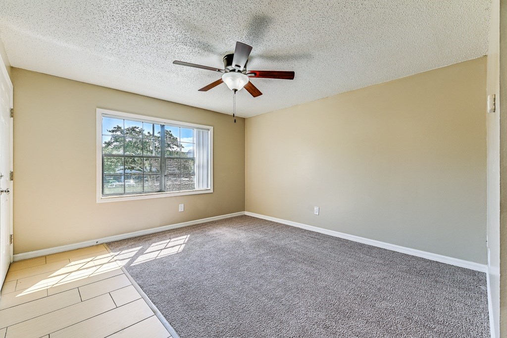A room with a ceiling fan and a window.