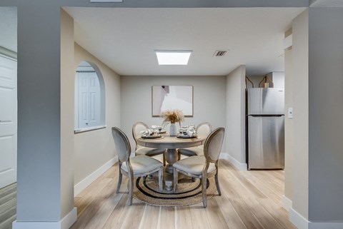 a dining area with a round table and four chairs