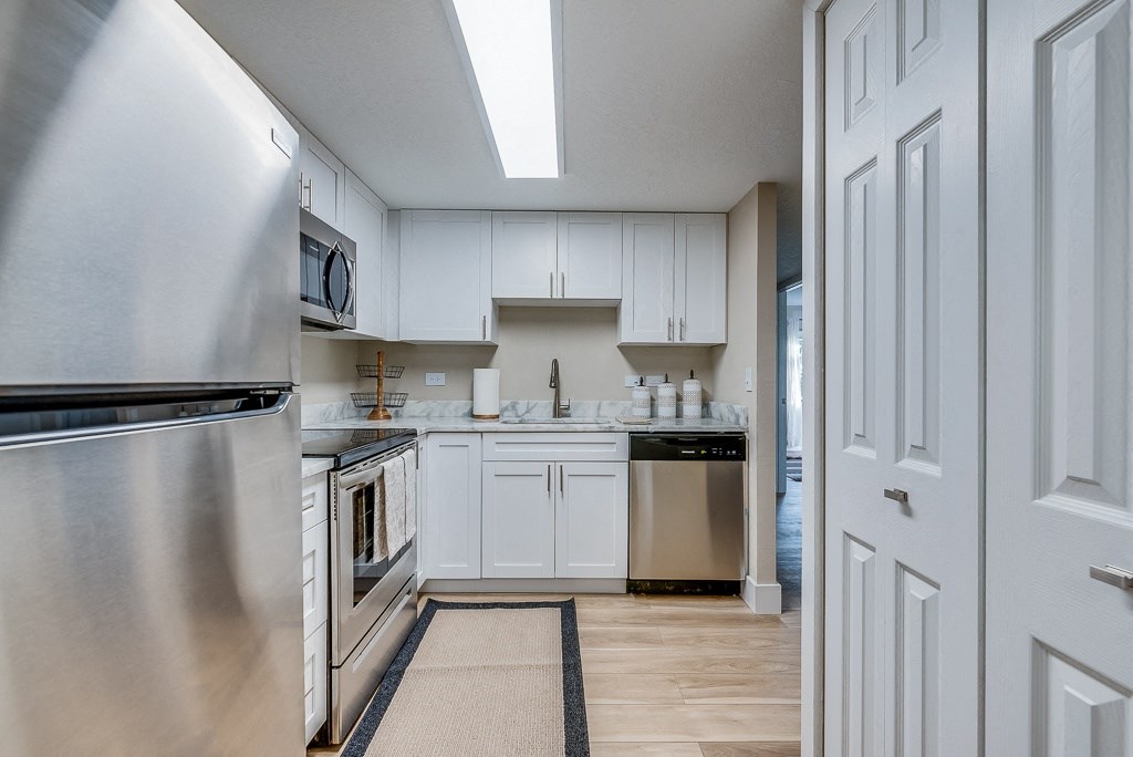 a kitchen with white cabinets and stainless steel appliances