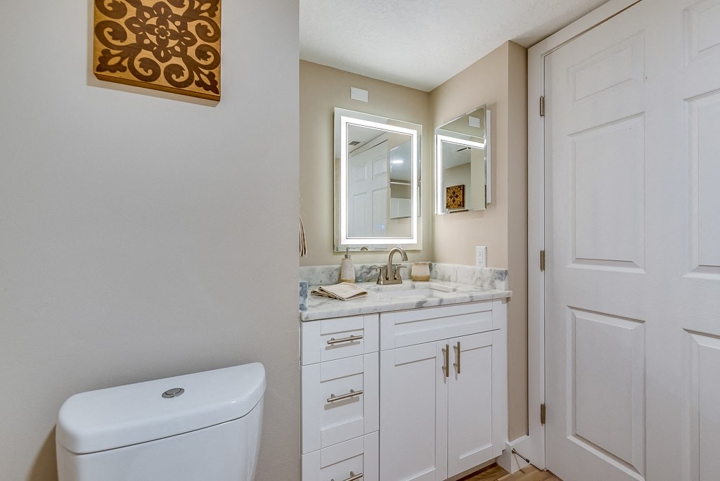 a bathroom with white cabinets and a white toilet