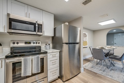 a kitchen with white cabinets and stainless steel appliances