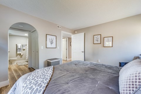 a bedroom with a large bed and a bathroom in the background