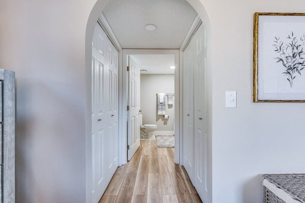a hallway in a home with white walls and wood floors