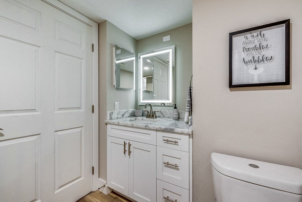a bathroom with white cabinets and a white toilet