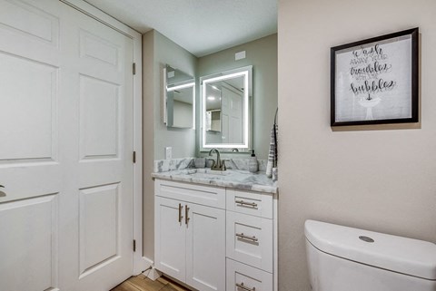 a bathroom with white cabinets and a white toilet