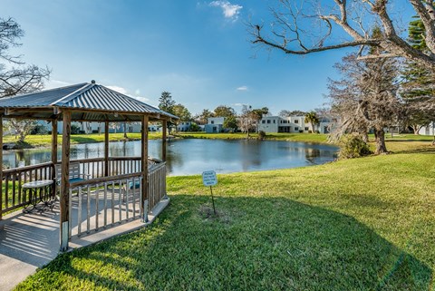 a gazebo with a sign in front of a lake