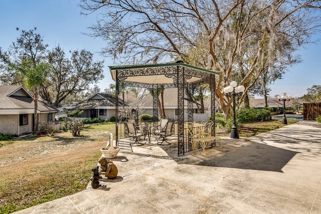 a gazebo with chairs and tables in a backyard