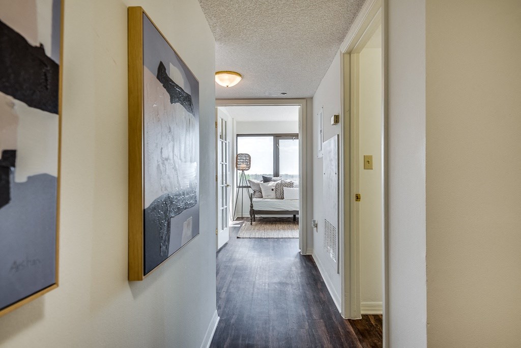a hallway with a painting on the wall and a couch in the distance