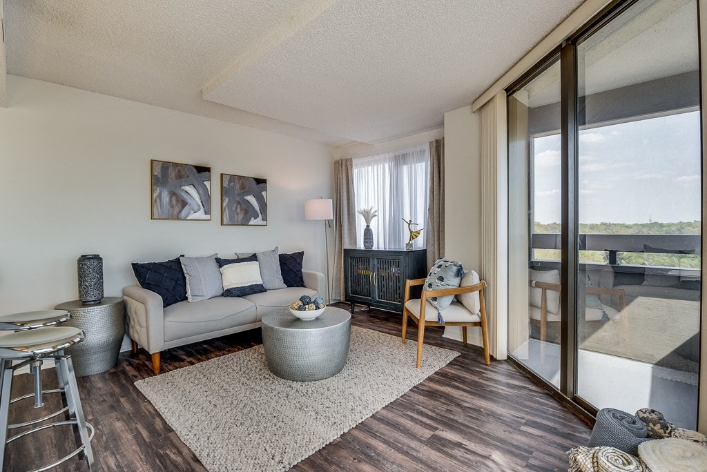 a living room with a sliding glass door leading to a balcony