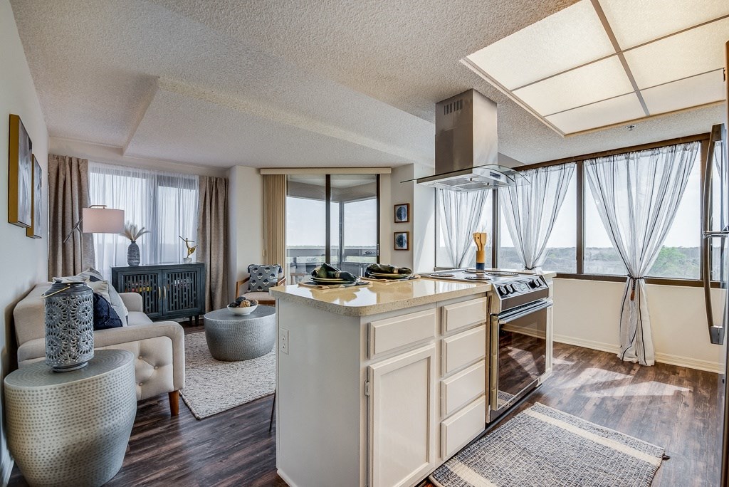 a kitchen with an island and a living room in the background