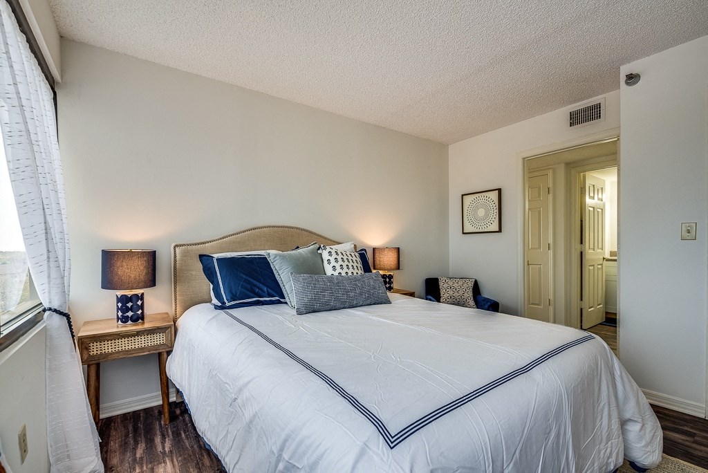 a bedroom with a large bed and two night stands with lamps