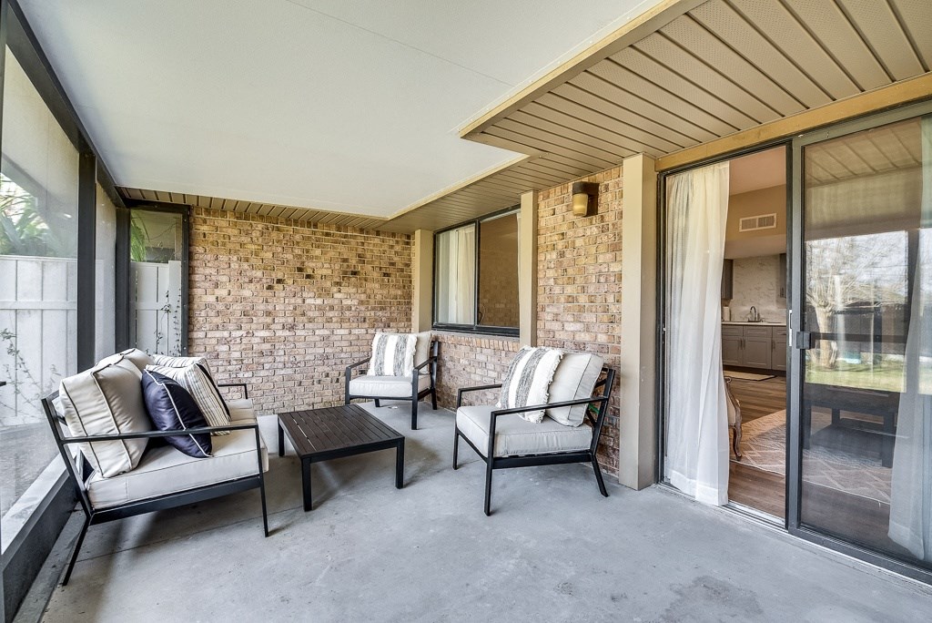 a covered patio with chairs and a coffee table