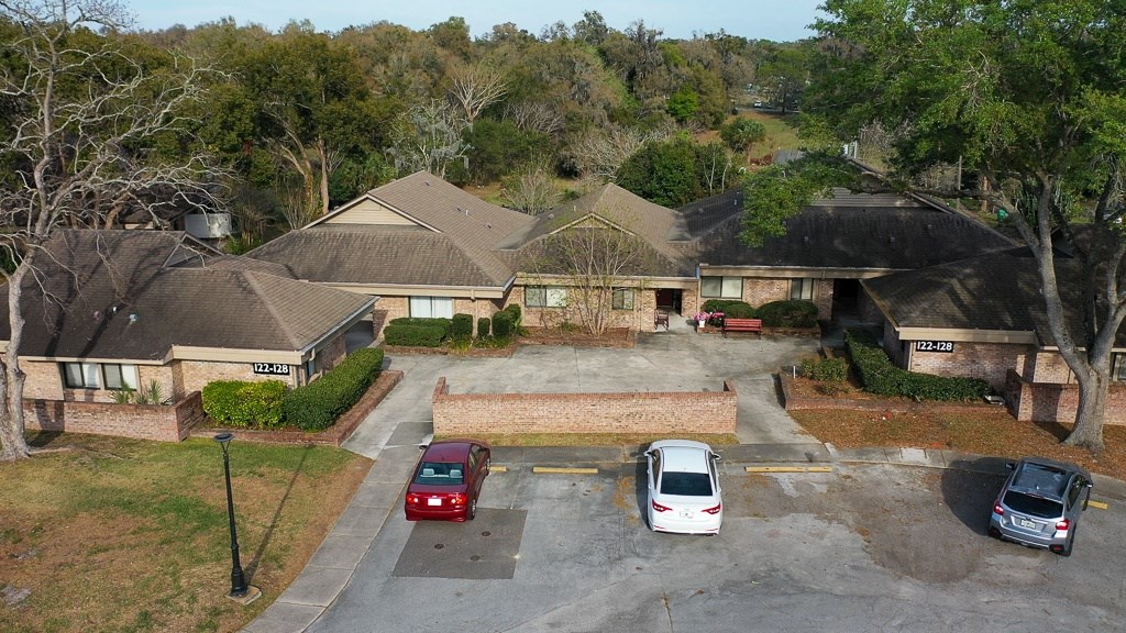 arial view of a house with a white car parked in the driveway