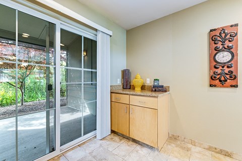 A room with a wooden cabinet and a clock on the wall.