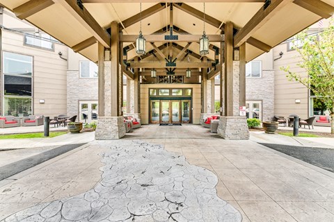 A large building with a covered walkway and a stone pathway leading to the entrance.
