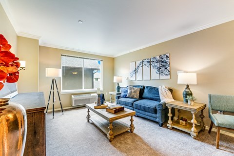 A living room with a blue couch and a wooden coffee table.
