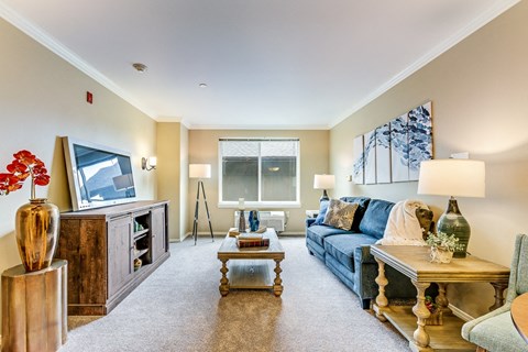 A living room with a blue couch and a wooden coffee table.