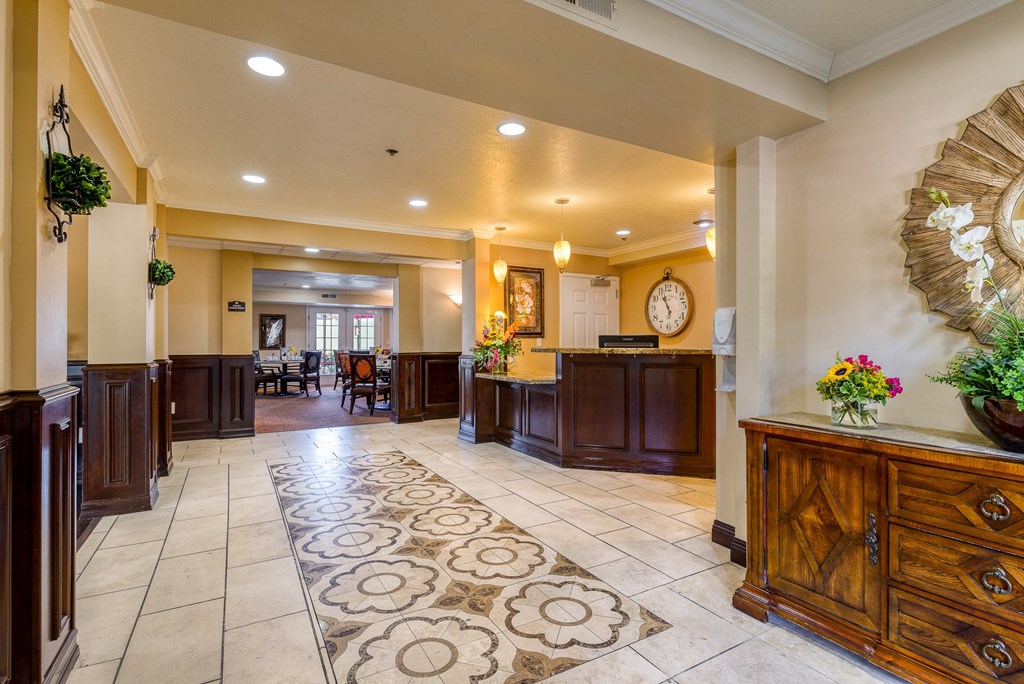 a lobby with a large rug and wooden furniture