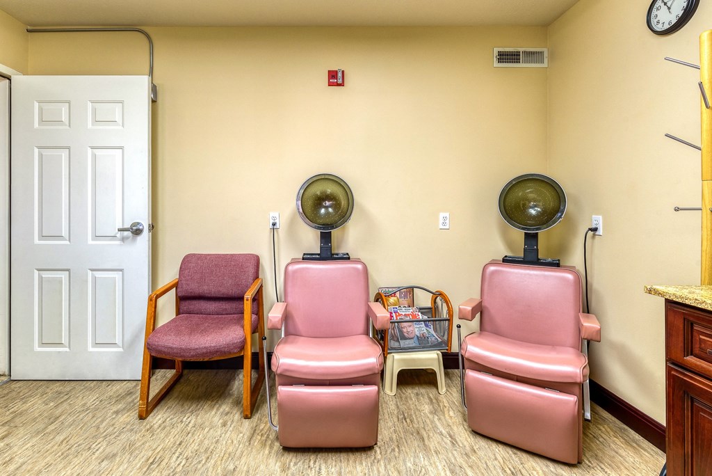 a room with three chairs and two fans