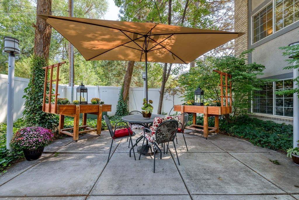 a patio with a table and chairs and a large umbrella