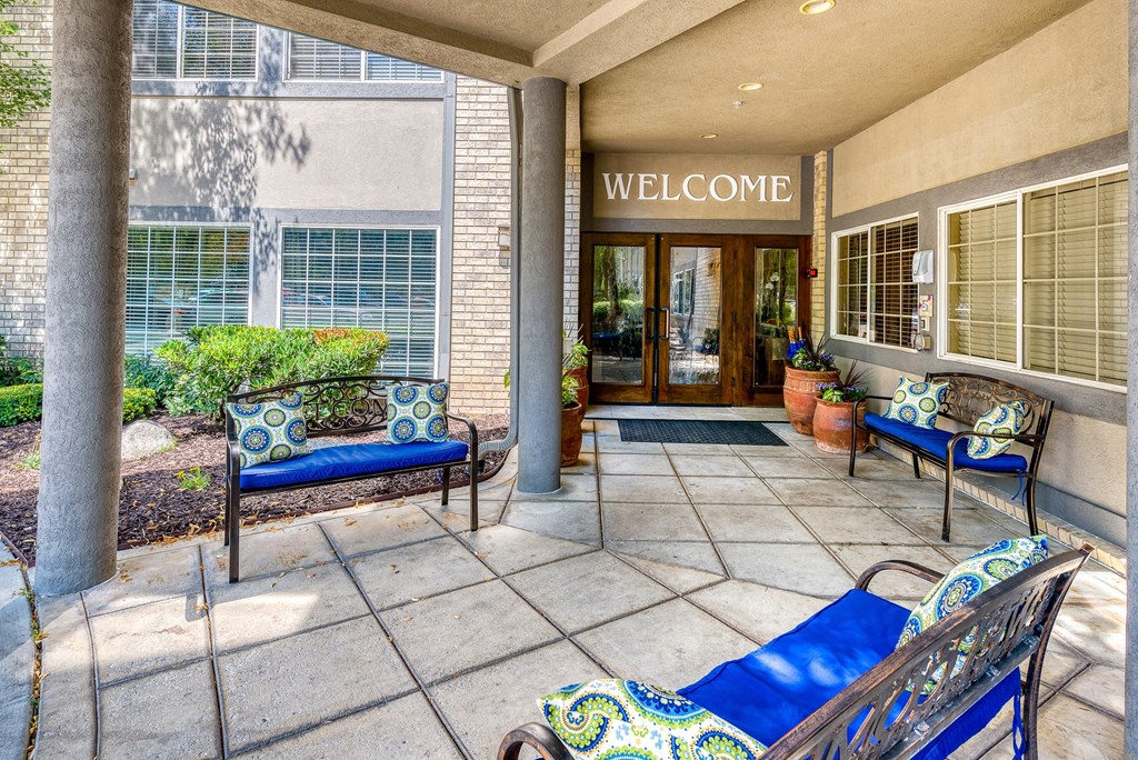 a patio with blue furniture and potted plants
