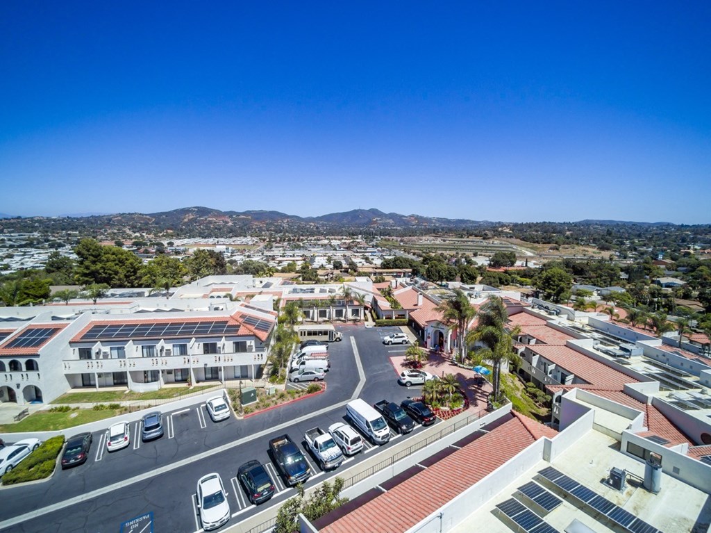 an aerial view of a building with cars parked on the street