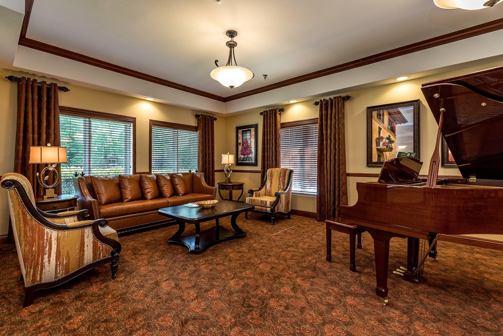 a living room with leather furniture and a piano