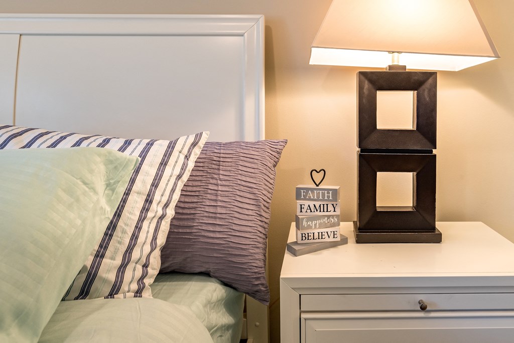 a bedroom with a bed and a night stand with a lamp
