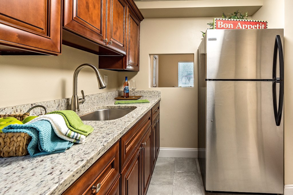 an updated kitchen with stainless steel appliances and granite counter tops