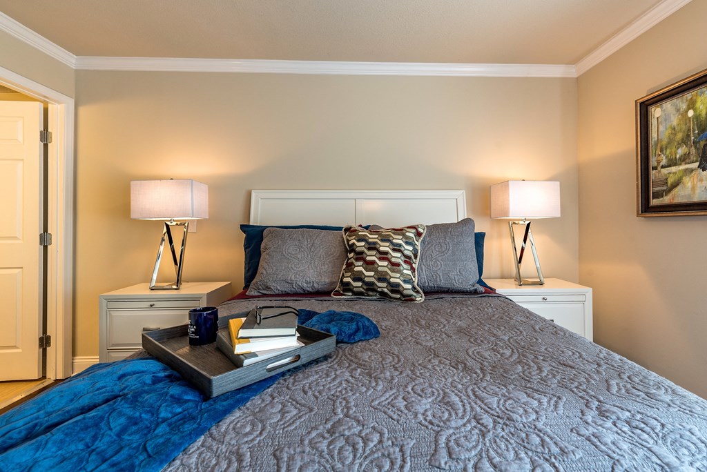 a bedroom with a bed with pillows and a tray on it