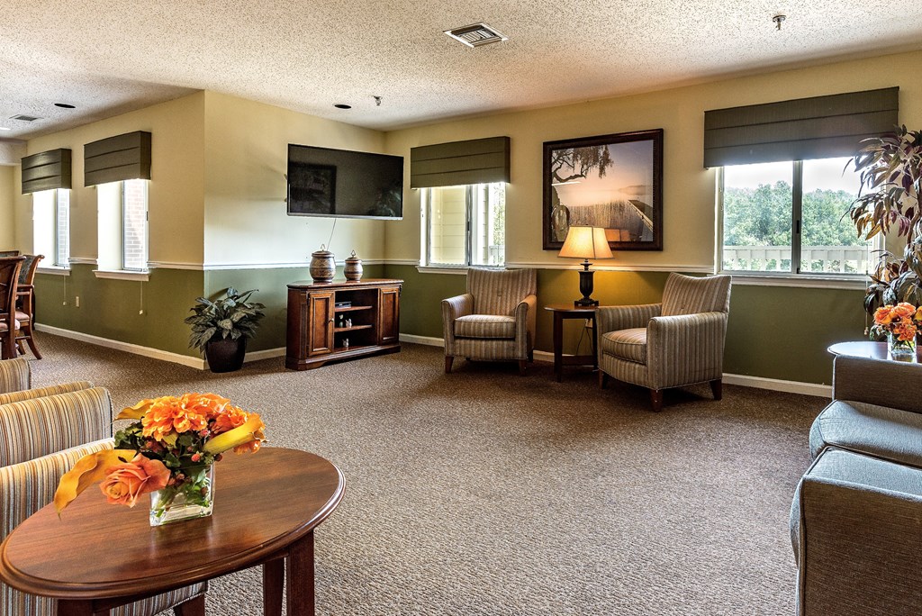 a living room filled with furniture and a table with flowers