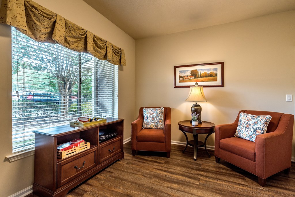 a living room with two chairs and a window
