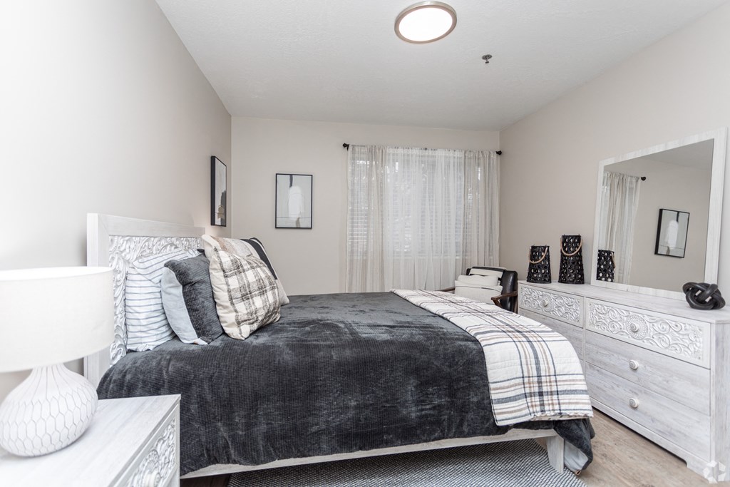 a bedroom with a bed and a dresser and a mirror