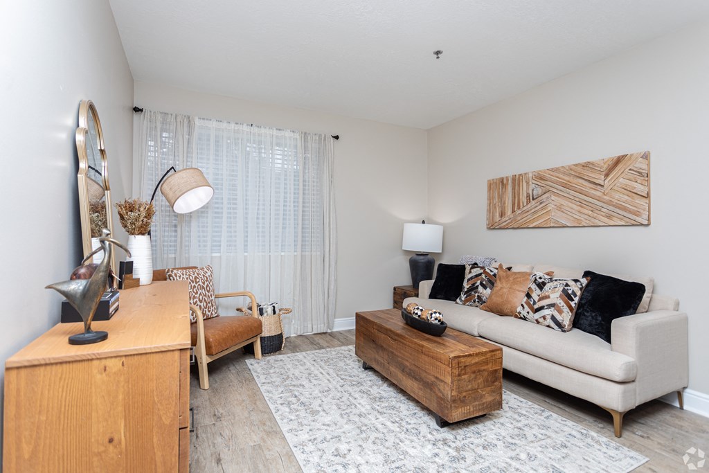 a living room with a couch and a chair and a desk