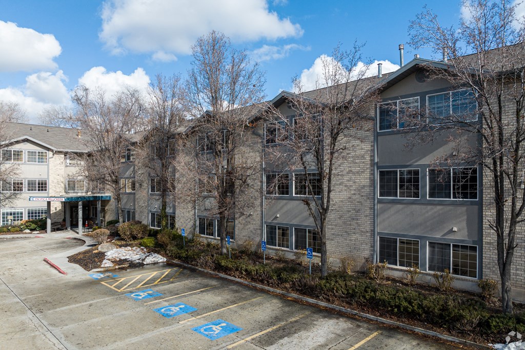 an apartment building with a parking lot in front of it