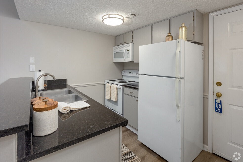 a kitchen with white appliances and a sink and a refrigerator