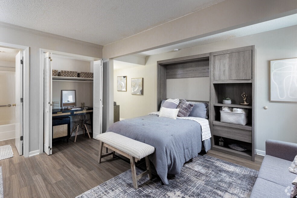 a bedroom with a bed and a living room with a desk